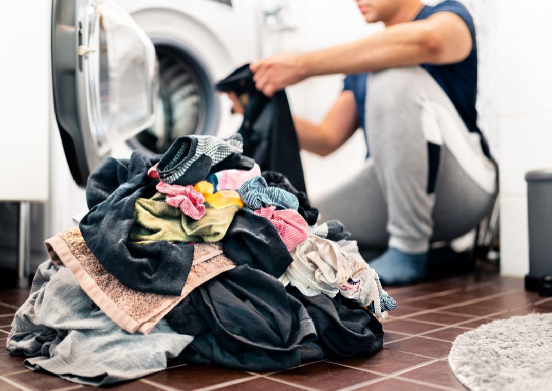 Man sorting clothing & underwear for washing