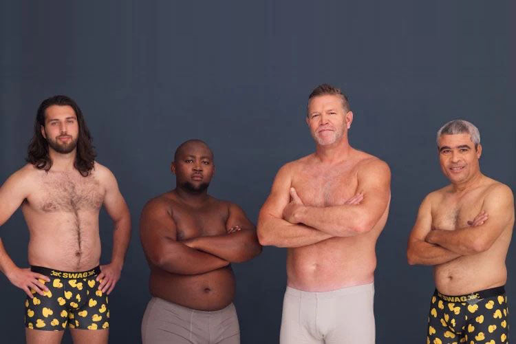 Four men in underwear standing confidently against a plain backdrop.