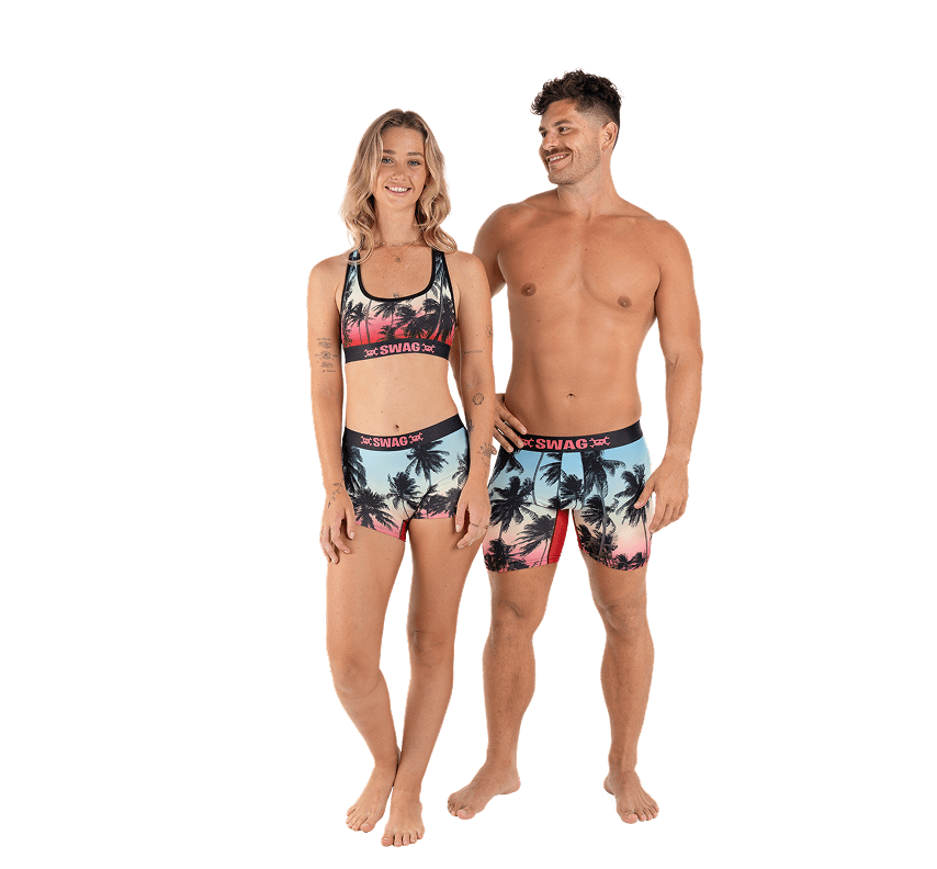 Man and woman wearing matching tropical-themed swimwear.